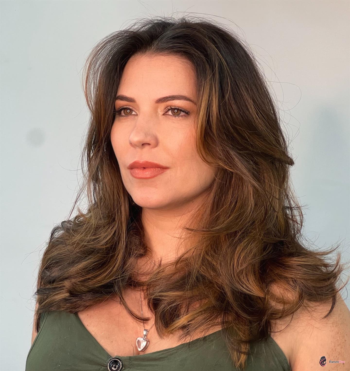 Voluminöser Blowout mit weichen Gesichtsstufen Achsellange Föhnfrisur für Frauen mit hohen Wangenknochen